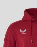 Close up of red hoodie chest area with white crest logo and red drawstrings.