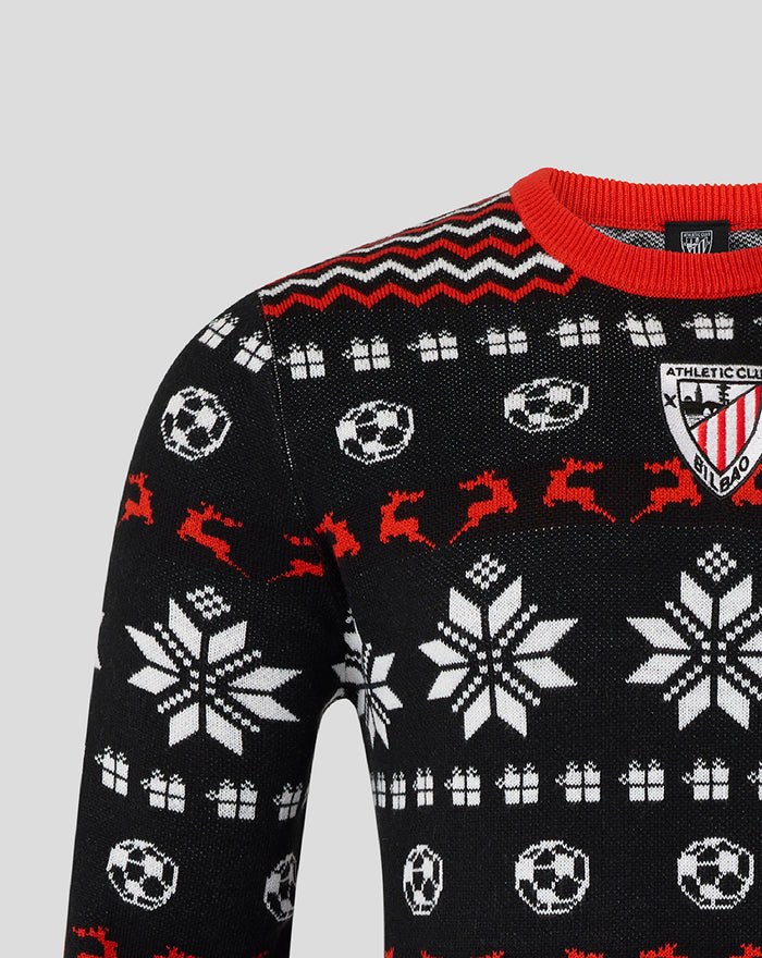 Close up of black Christmas jumper with white snowflakes gift motifs red trim and a club crest on the chest