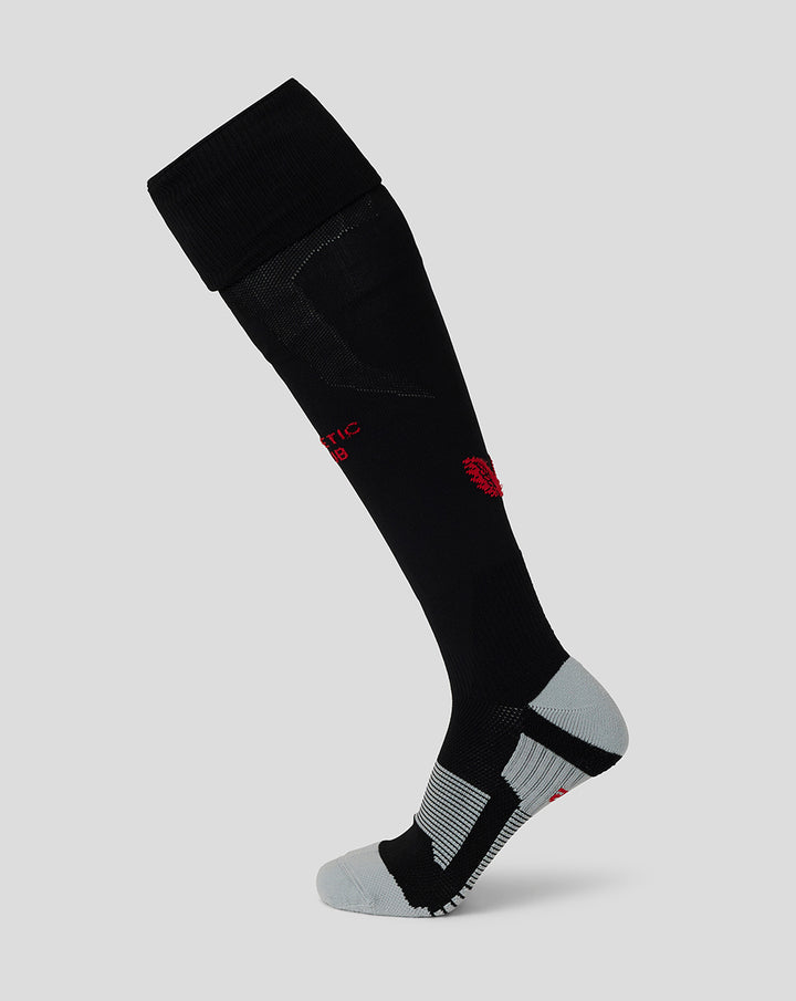 Black junior athletic soccer sock with red crest and gray heel and toe panels on a light gray background.