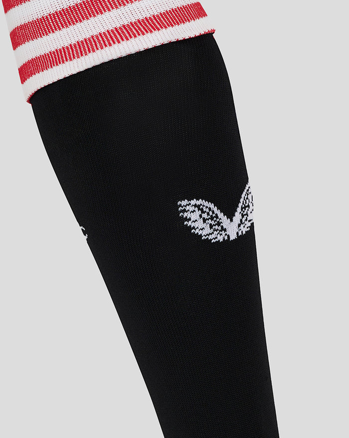 Close-up of white emblem on black sock against light background