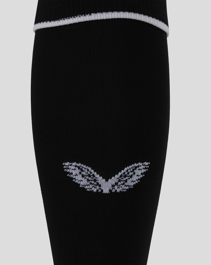 Close up of black home goalkeeper footless sock knit fabric with a white hoop at the top and an embroidered club crest near the ankle