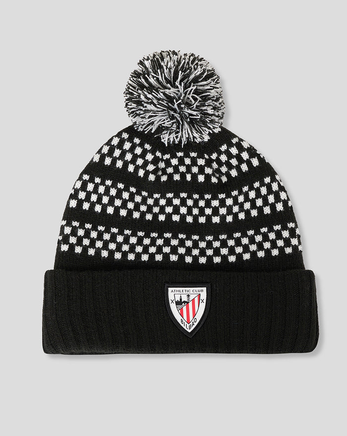 Gorro de punto negro y blanco con pompón y patrón de puntos