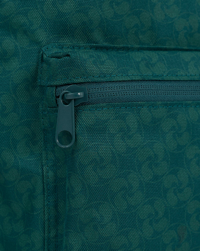 Close-up of teal green backpack fabric with zipper and front pocket
