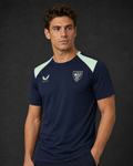 Male model wearing navy performance short sleeve tee with mint shoulder panels and crest emblem
